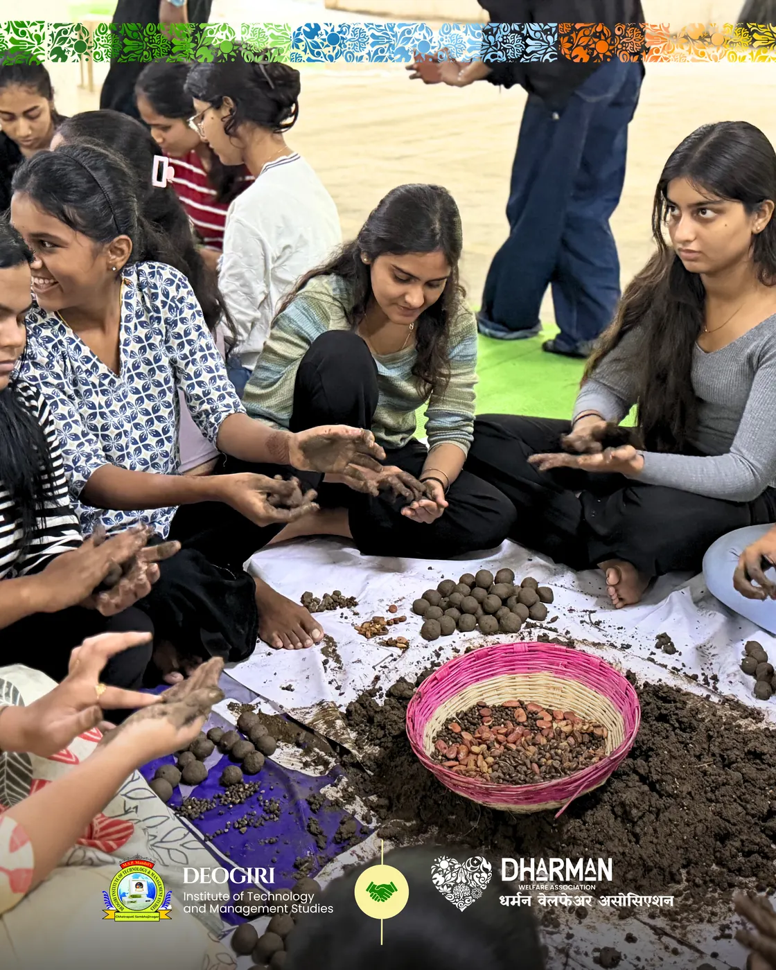 A large group of students shaping seed balls on the lawn.