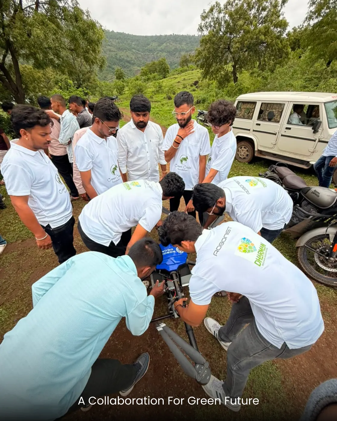Volunteers loading seed balls into the drone hopper on the hillside.
