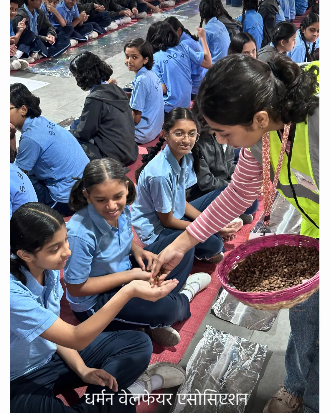 SBOA Public School students in blue uniforms rolling seed balls.