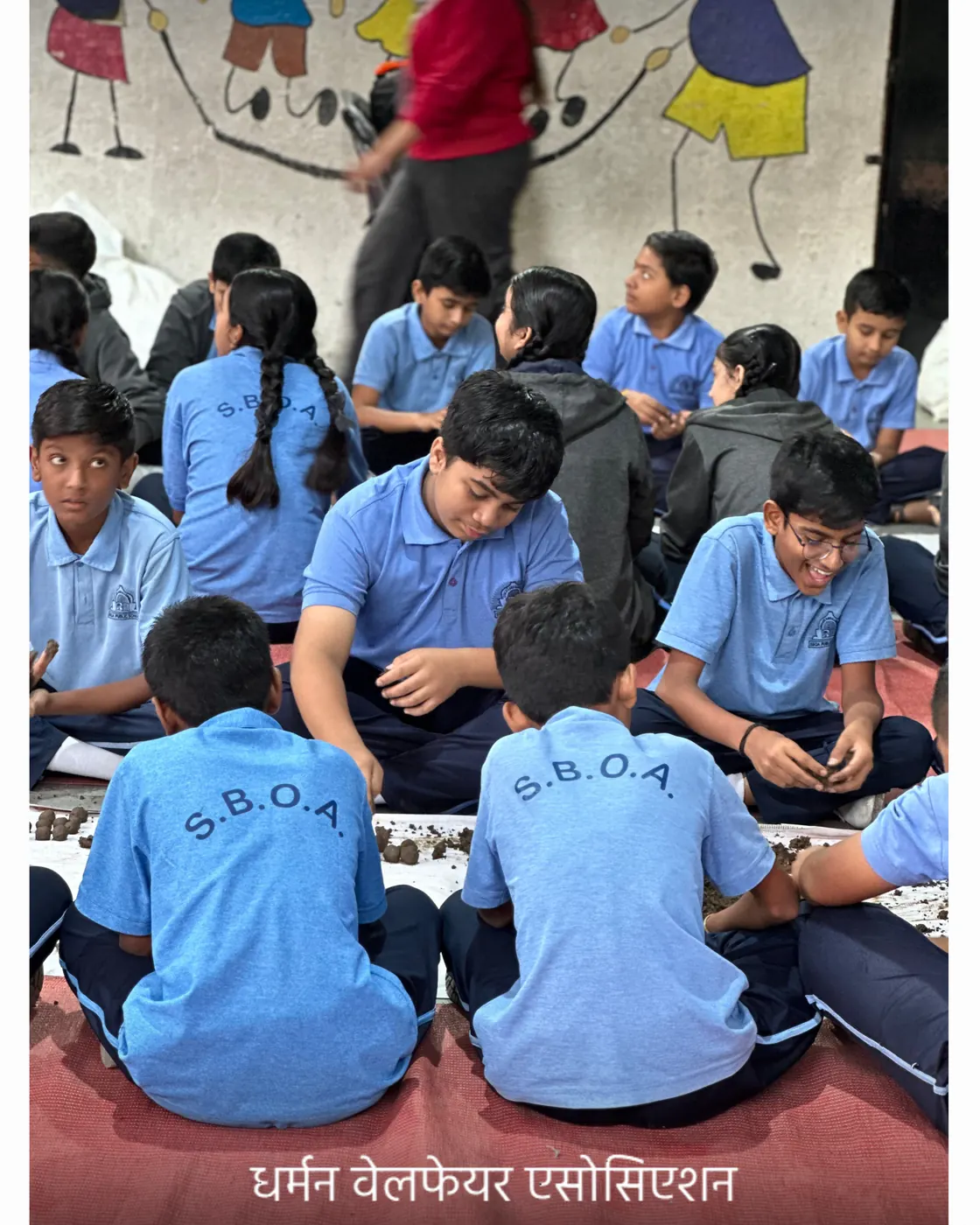 Students working along a row of soil and seed trays.