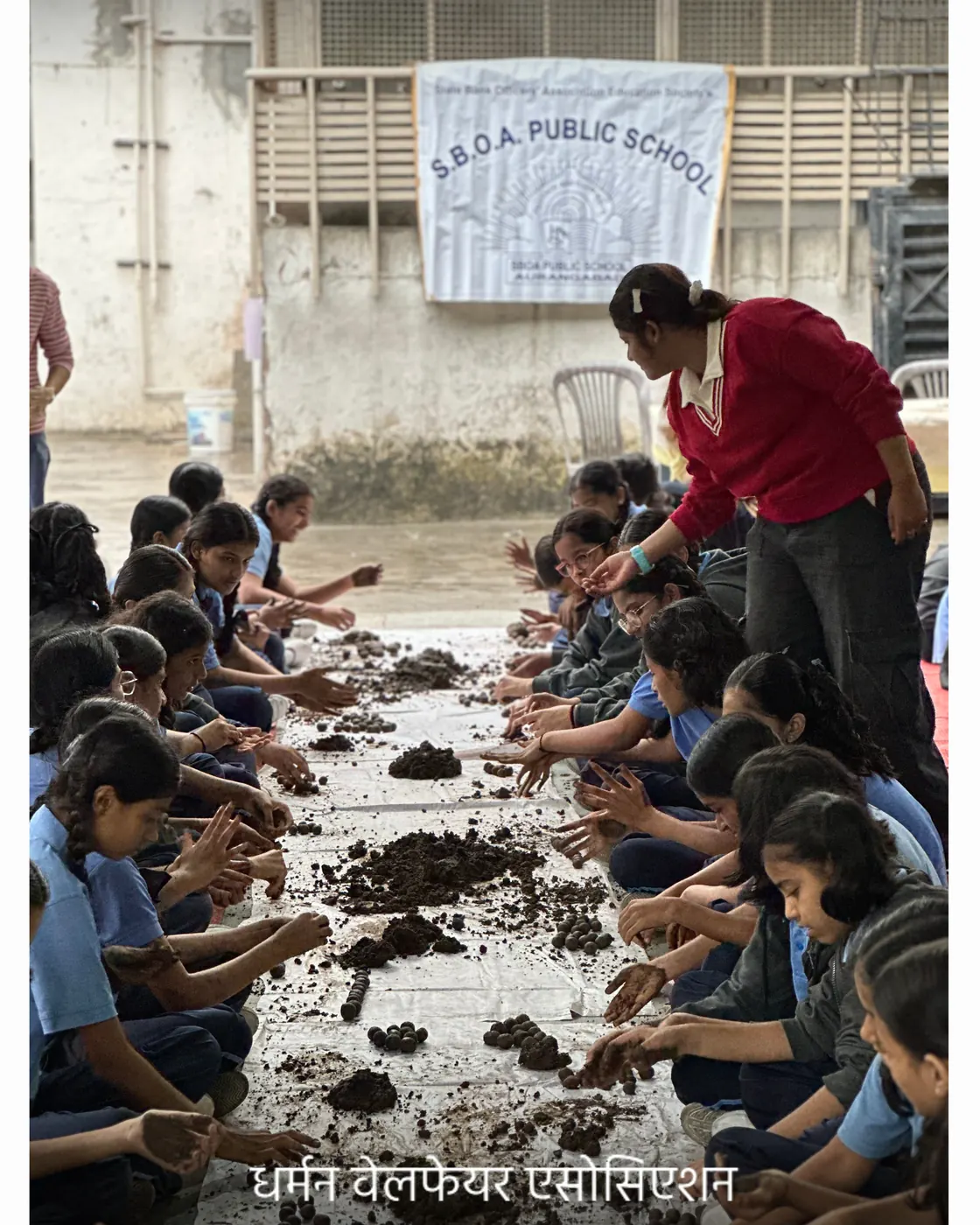 A student concentrating on shaping a seed ball.