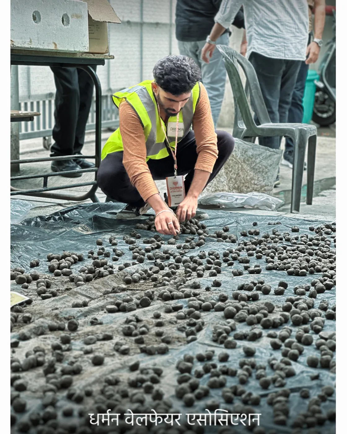 A volunteer laying out seed balls to dry.