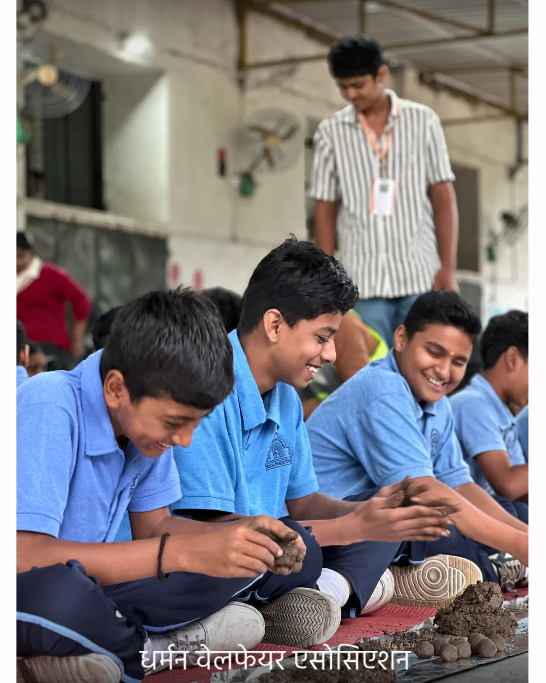 School students crowded around a demonstration of seed-ball rolling.