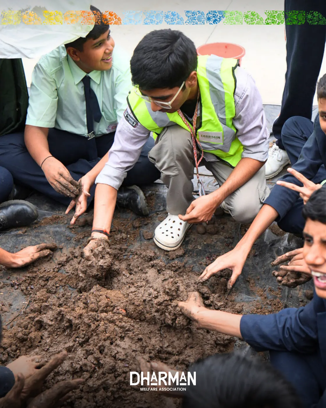 Students and volunteers pressing seeds into soil together.