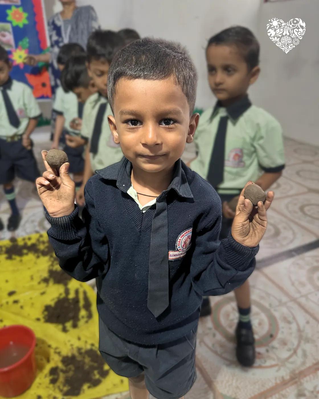 A pupil holding up a completed seed ball.