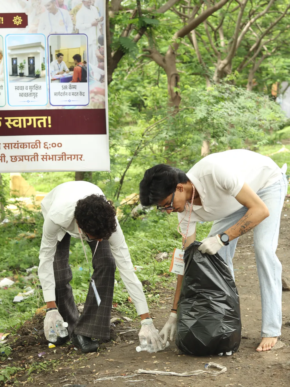 Volunteers clearing waste into bags during a Dharman cleanliness drive.
